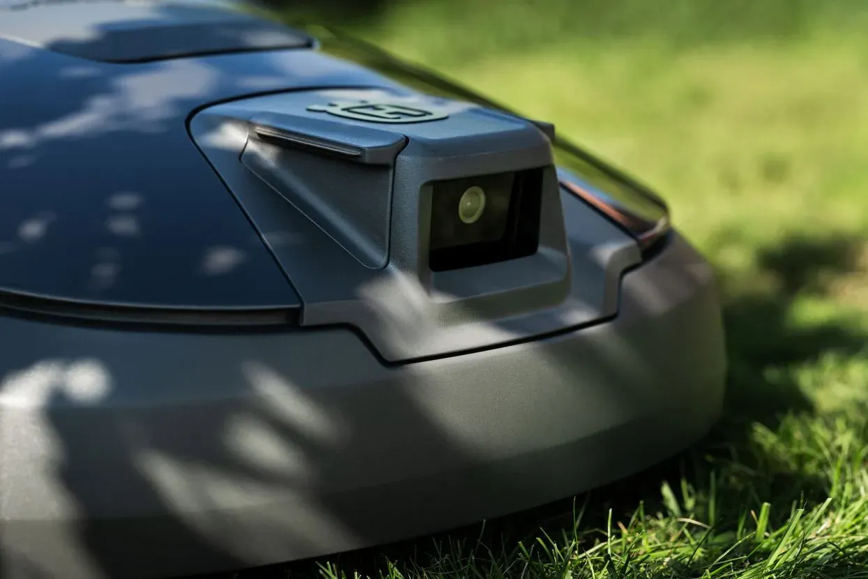 Gros plan sur la caméra logée à l'avant du capot de l'Automower 312V, posé dans l'herbe